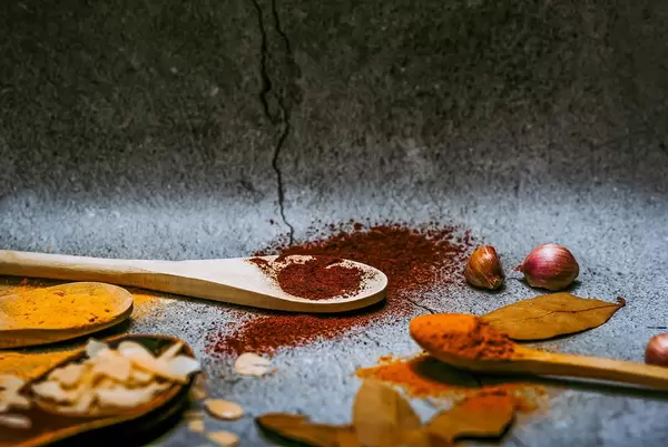 Four wooden spoons with various spices