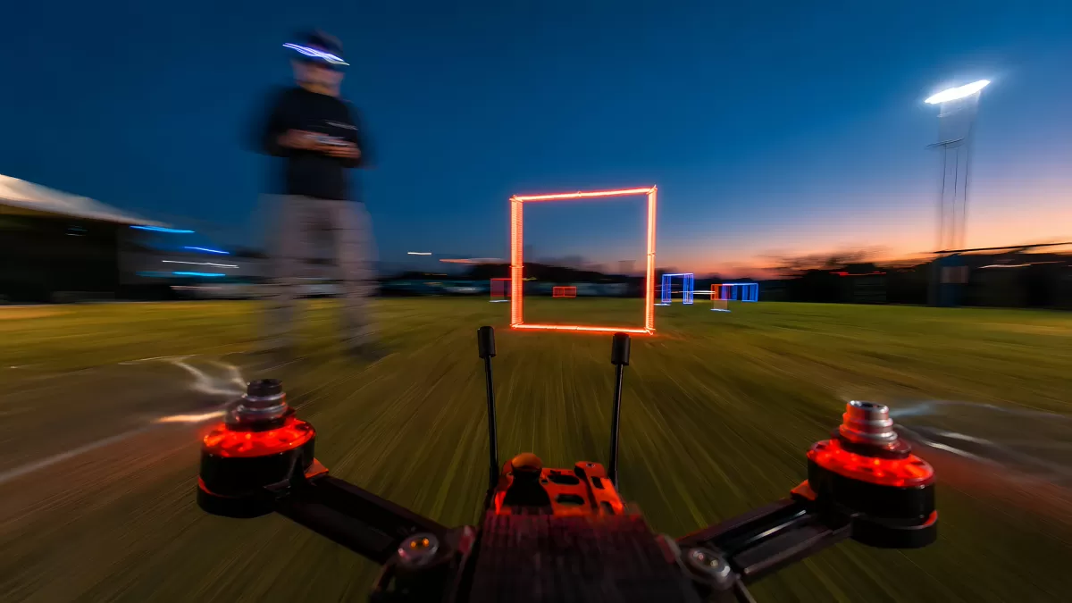 FPV-Drohne fliegt nachts durch leuchtende Tore