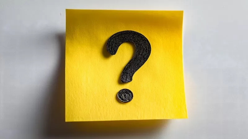 Fragezeichen auf gelbem Klebezettel vor weißem Hintergrund