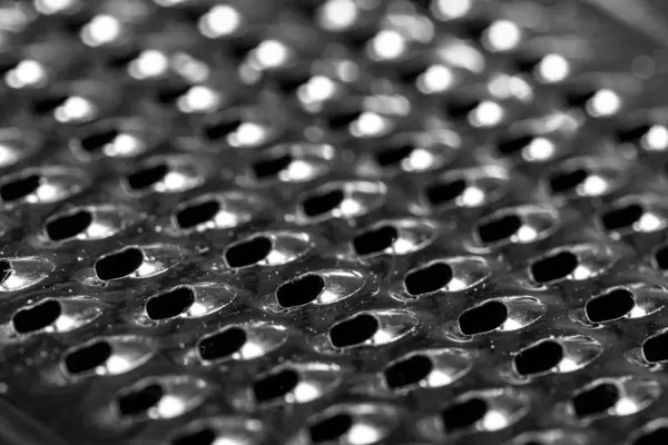 Fragment of a metal grater. Metal grater close-up