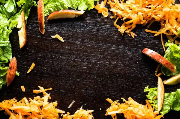 Frame formed with shredded carrot, lettuce, and apple slices