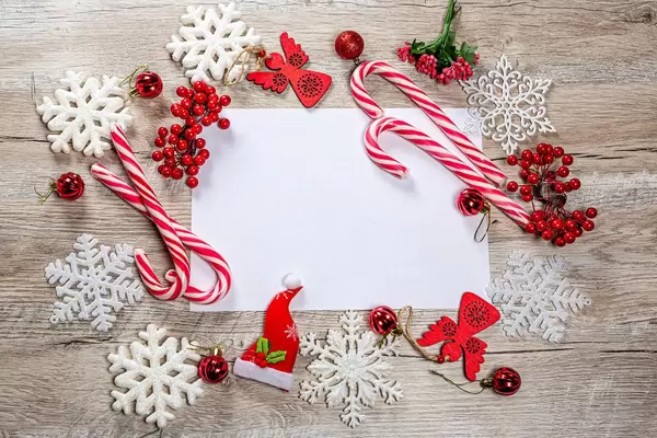 Frame of Christmas decor and white snowflakes on wooden background with free space