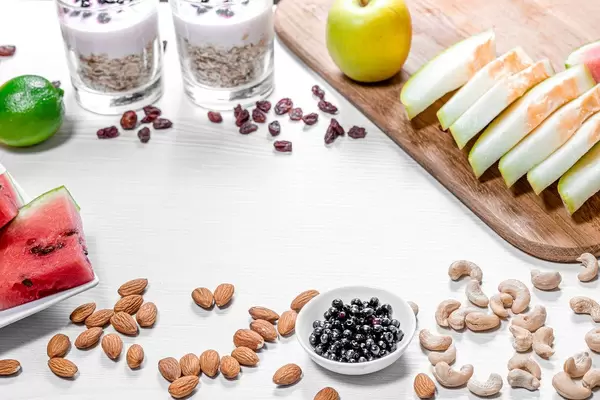Frame of fruits, oatmeal and nuts for a healthy breakfast on a white wooden background (Flip 2019)