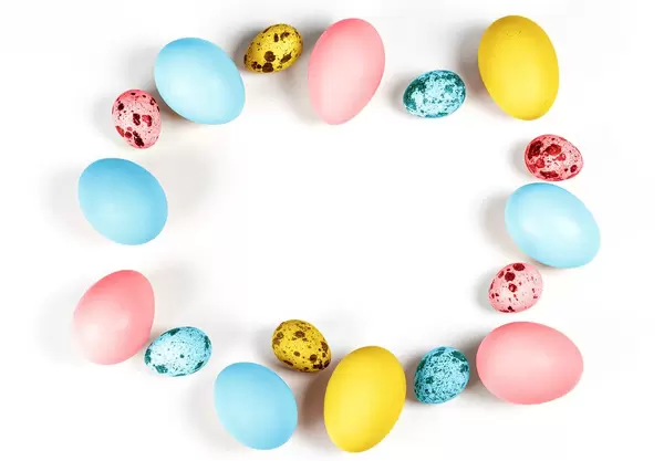 Frame of multicolored quail and chicken eggs on a white background. Free space for Easter greetings (Flip 2020)