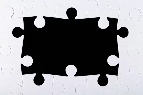 Frame of white puzzles on a black background with free space (Flip 2020)