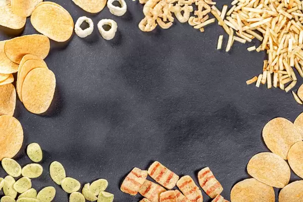 Frame with a variety of beer snacks on a black background. Top view