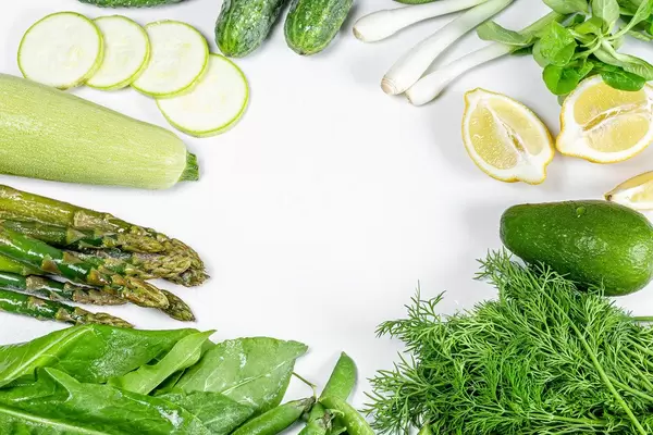 Frame with fresh vegetables and herbs on a white background with free space