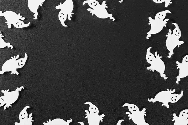 Frame with white ghosts decor on dark background. Halloween concept