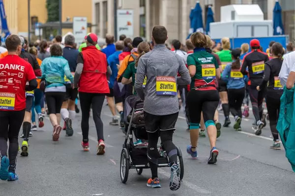 Frankfurter Marathon Staffelläufer von hinten fotografiert - einMann mit Kinderwagen