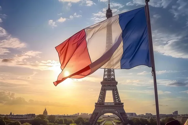 Französische Flagge am Eiffelturm bei Sonnenuntergang