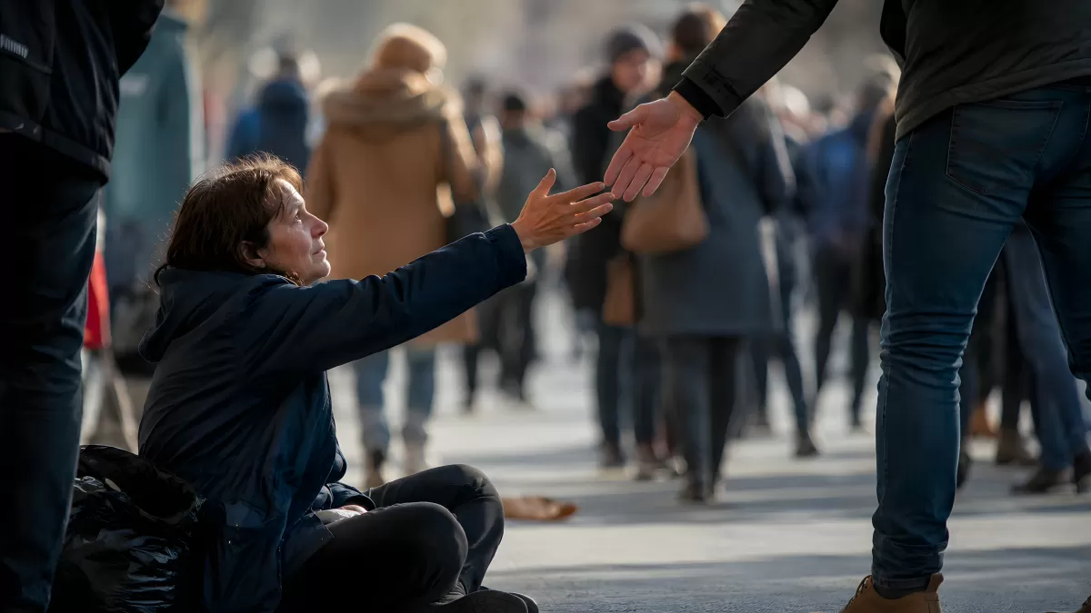 Frau auf der Straße reicht einem Helfer die Hand