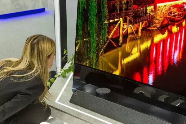 Frau begutachtet die Bildqualität des zukunftsweisenden 8K Fernsehers Metz Oled