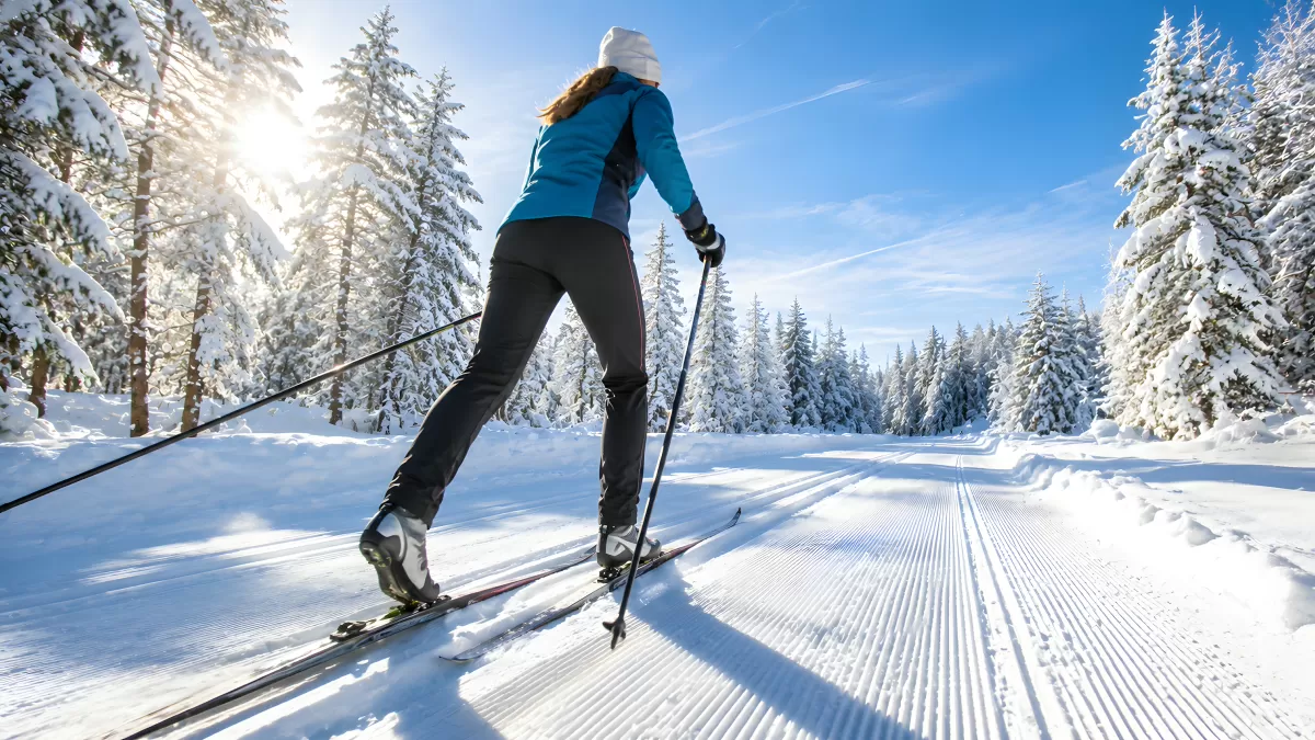 Frau beim Skilanglauf im verschneiten Winterwald
