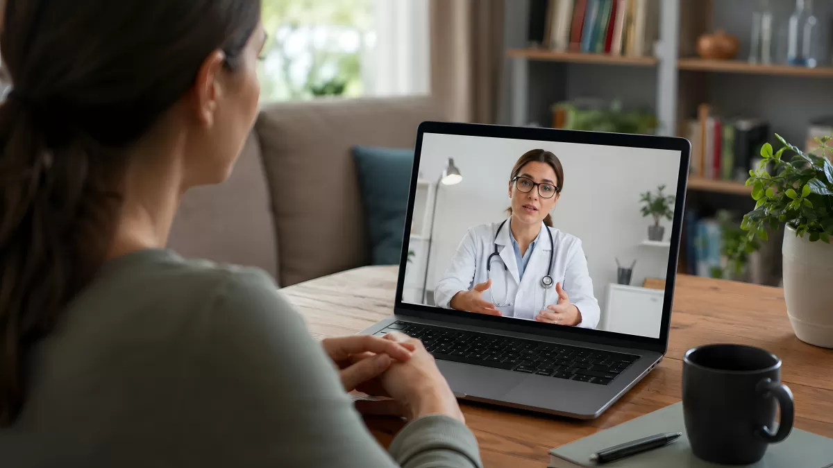 Frau beim Videogespräch mit Ärztin am Laptop zuhause