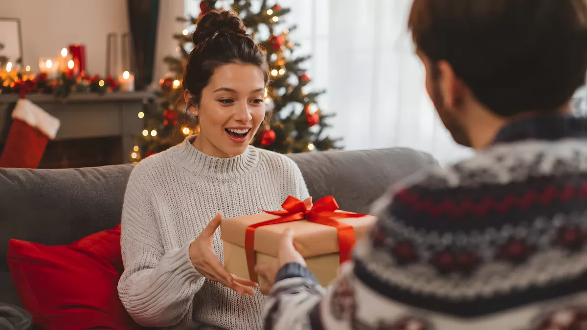 Frau empfängt Weihnachtsgeschenk mit roter Schleife