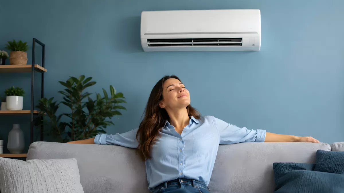 Frau entspannt auf Sofa unter Klimaanlage zuhause