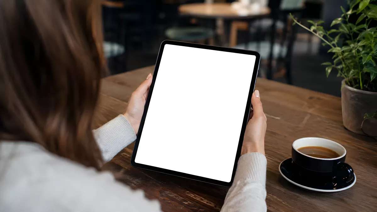 Frau hält Tablet mit weißem Bildschirm im Café