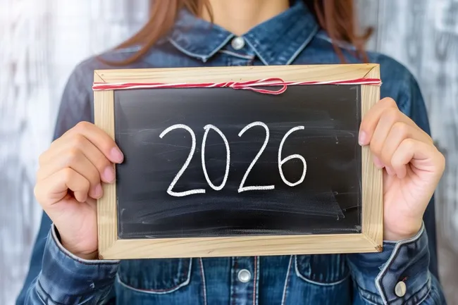 Frau hält Tafel mit Jahreszahl 2026