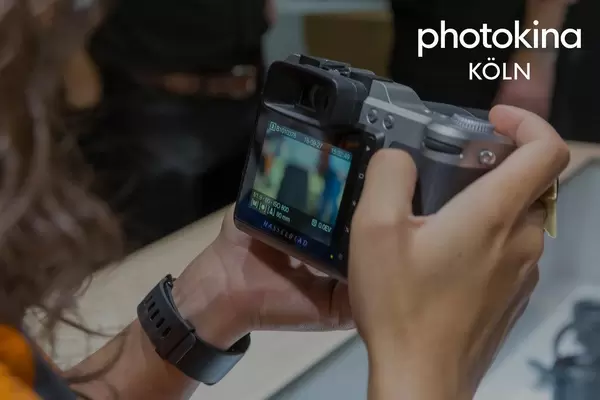 Frau hält einen Hasselblad-Fotoapparat neben dem Bildtitel "photokina Köln"