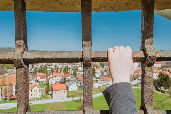 Frau hält Fenstergitter in der Hand