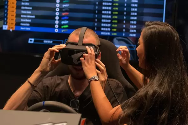 Frau hilft Mann beim Testen der Virtual Reality-Brille von AORUS