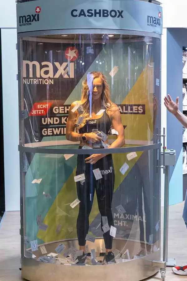 Frau in einer Cashbox von maxi Nutrition auf der Fibo in Köln