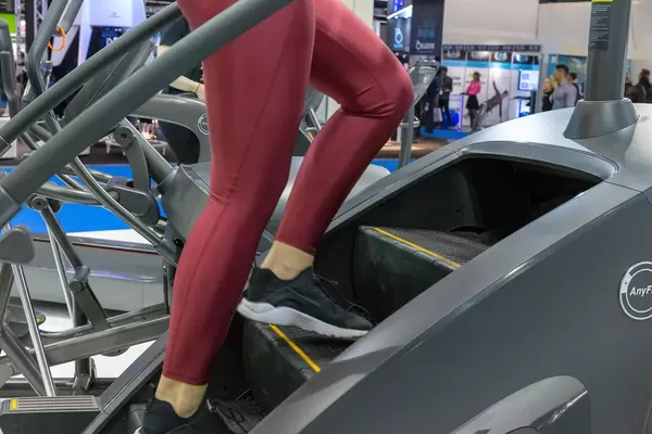 Frau in rotem Leggings träniert auf einer Anyfit Schrittmaschine an der Fibo-Messe Köln