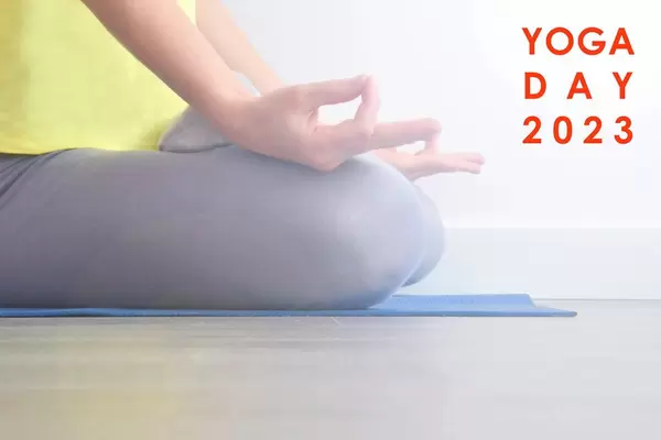 Frau macht Entspannungsübungen mit Meditation auf einer Yogamatte, neben dem Bildtitel "Yoga Day 2023"
