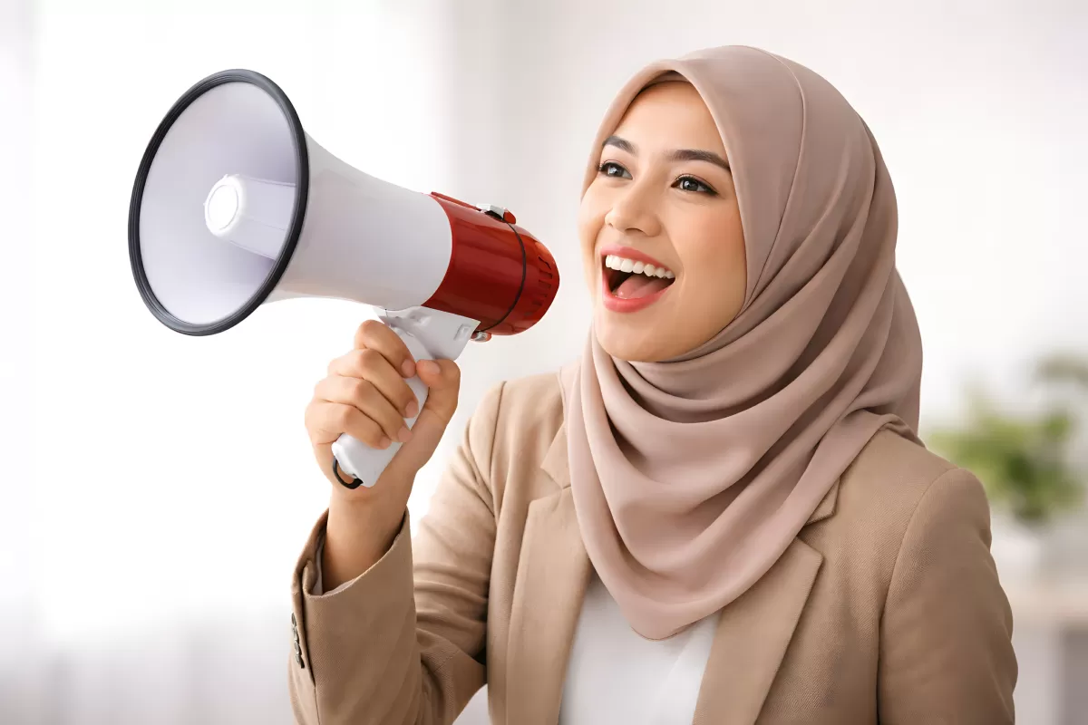 Frau mit Hijab spricht lautstark ins Megafon