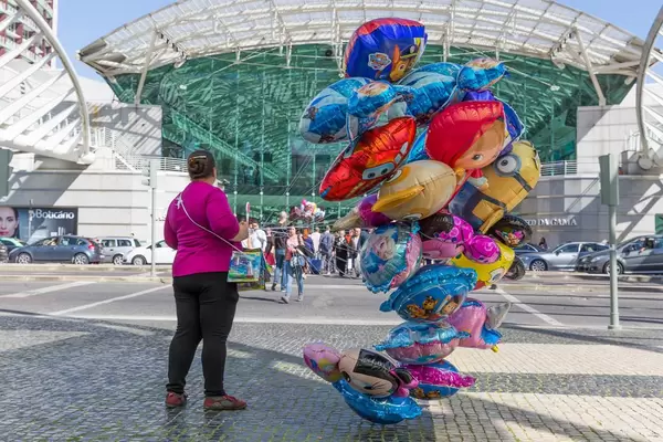 Frau mit Luftballons vor Einkaufszentrum Vasco da Gama