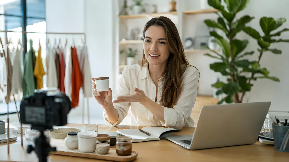 Frau präsentiert Kerzenprodukt vor Kamera als Content Creator