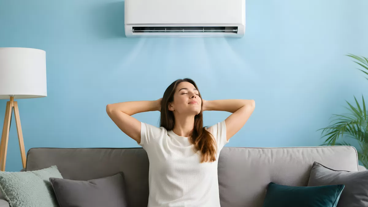 Frau relaxt auf Sofa unter laufender Klimaanlage