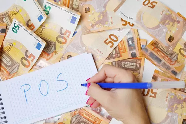 Frau schreiben "P.O.S." (Point of Sale) auf einen Zettel zwischen 50-Euro-Geldscheinen