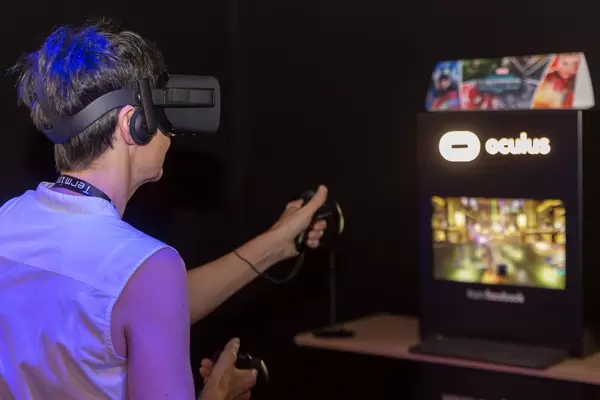 Frau spielt mit dem Oculus Rift Headset und Oculus Rift Touch Controllern