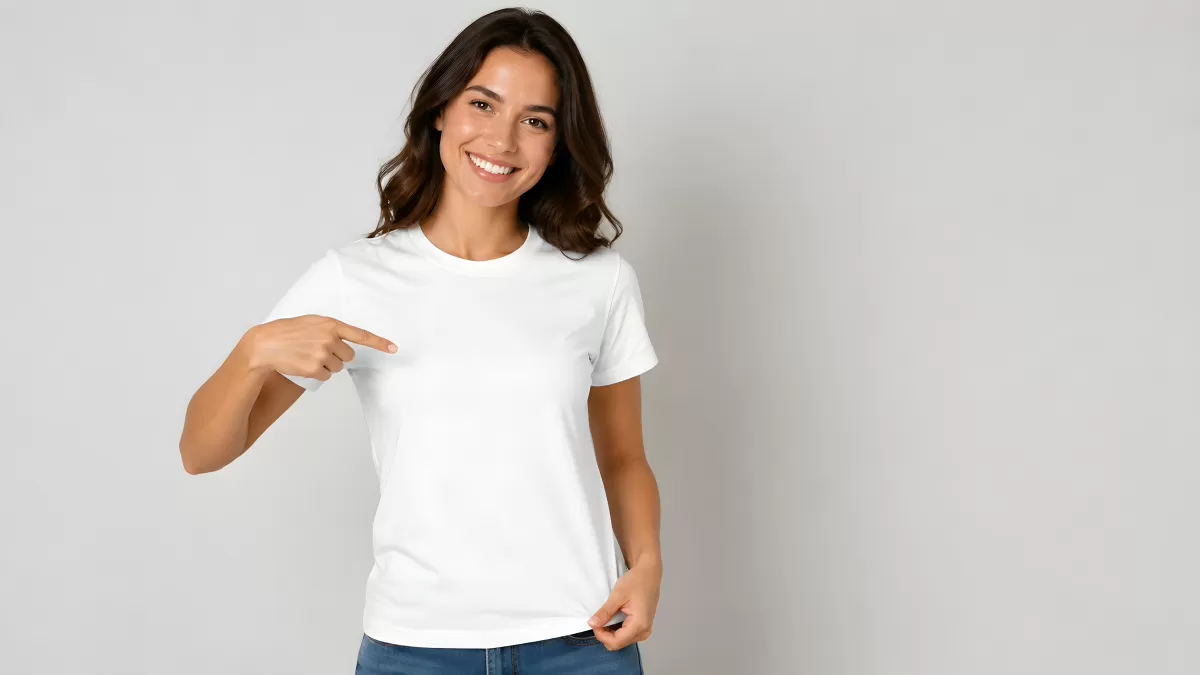Frau zeigt lächelnd auf ihr weißes T-Shirt