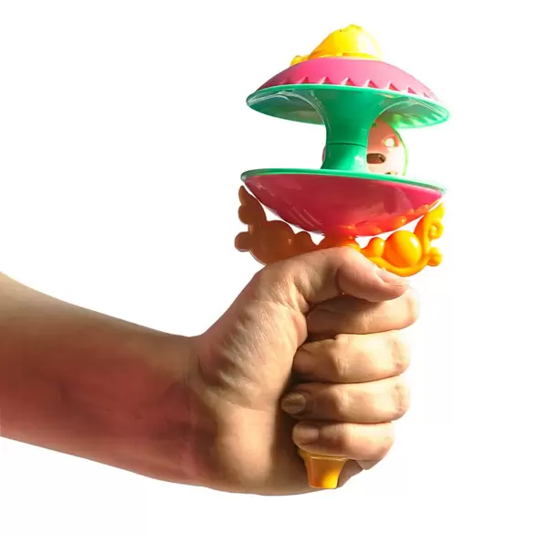 Frauenhand hält bunte Baby-Spielzeugrassel für Neugeborene in der Hand, isoliert vor weiß