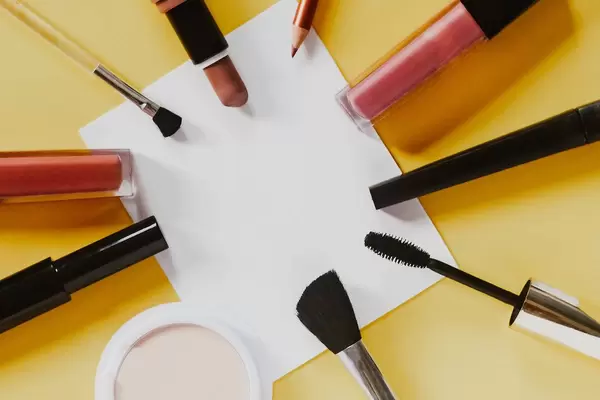 Frauenutensilien für Make-Up und Schminke auf einem Pastelhintergrund