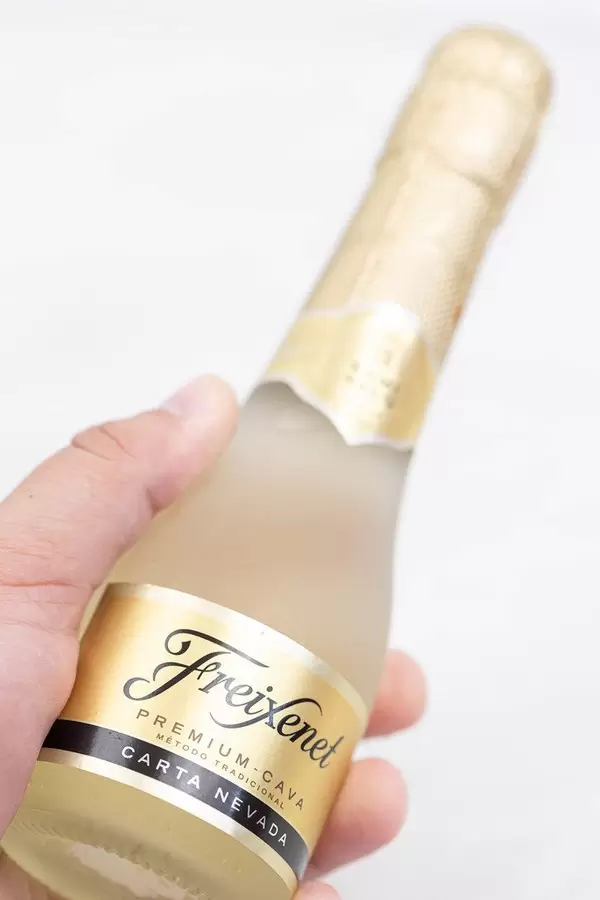 Freixenet bottle in the hand with copy space