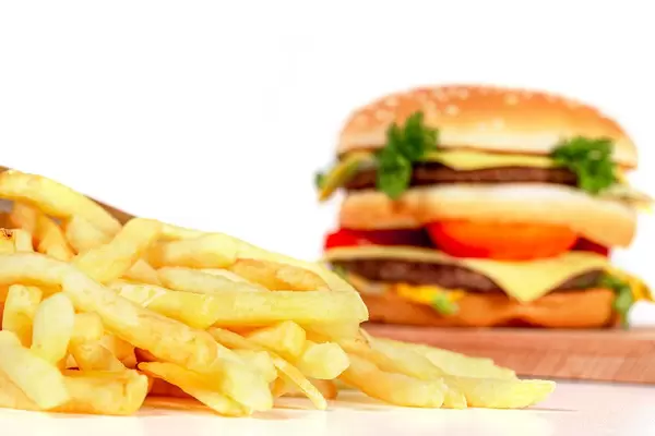 French fries and burger on white