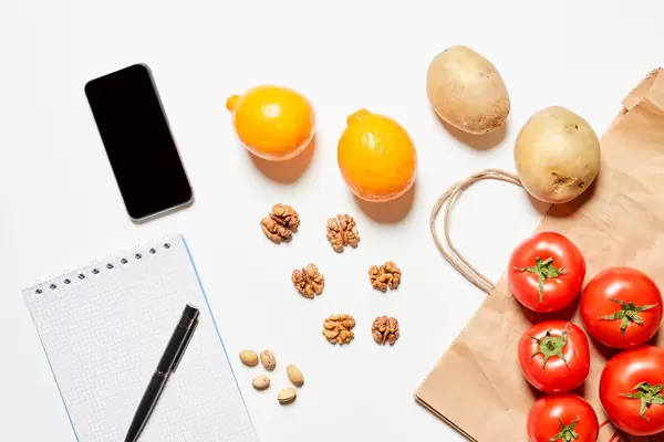 Fresh and organic vegetables, nuts and empty notepad with pen