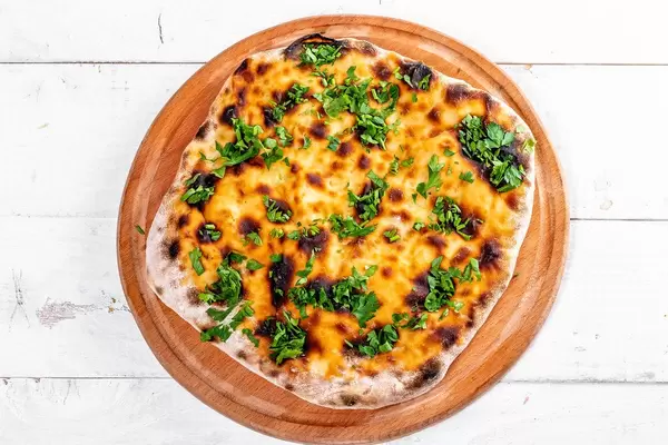 Fresh baked khachapuri with cheese on white wooden background (Flip 2019)