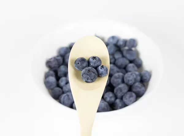 Fresh blueberries in wooden spoon