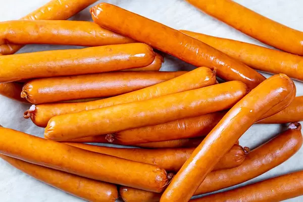 Fresh boiled sausages on white table