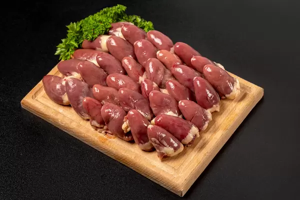 Fresh chicken hearts on dark background with parsley