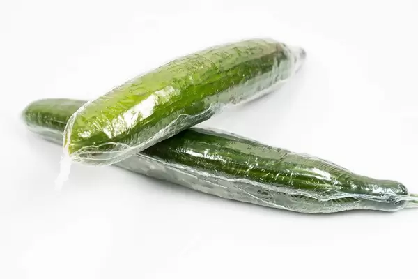 Fresh Cucumber in the plastic wrap above white background (Flip 2020)