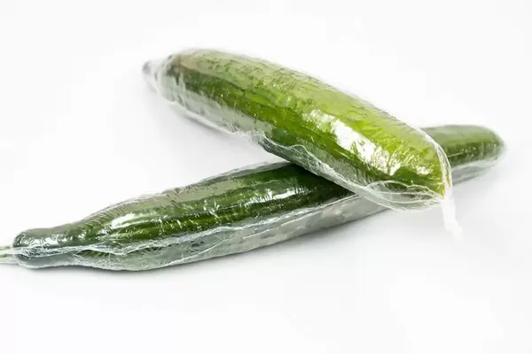 Fresh Cucumber in the plastic wrap above white background