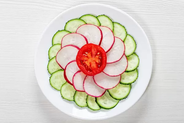 Fresh diet salad of cucumber, radish and tomato. Top view (Flip 2019)