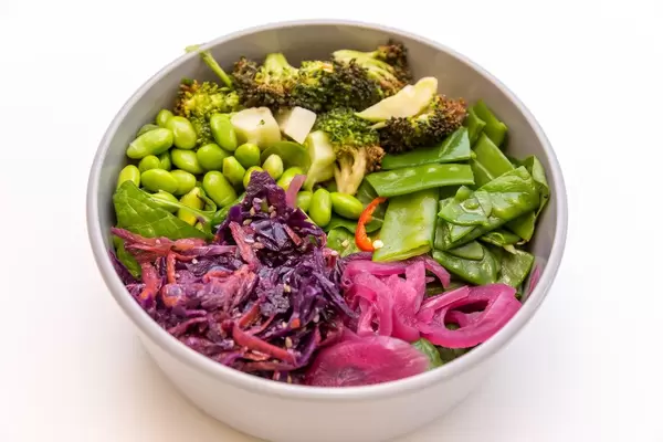 Fresh Eden Bowl mit Zuckerschoten, Edamame, Spinatsalat, gerösteter Brokkoli, Ruccola, eingelegte Zwiebeln, Sesam-Rohkostsalat, Koriander und Sesam-Ingwer Dressing