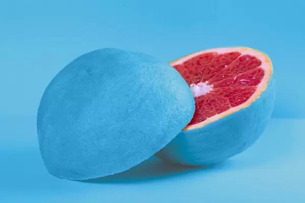 Fresh grapefruit halves with blue peel on blue background