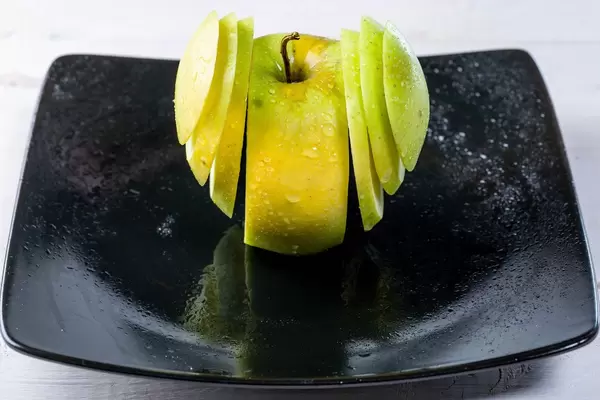 Fresh green Apple sliced on a plate